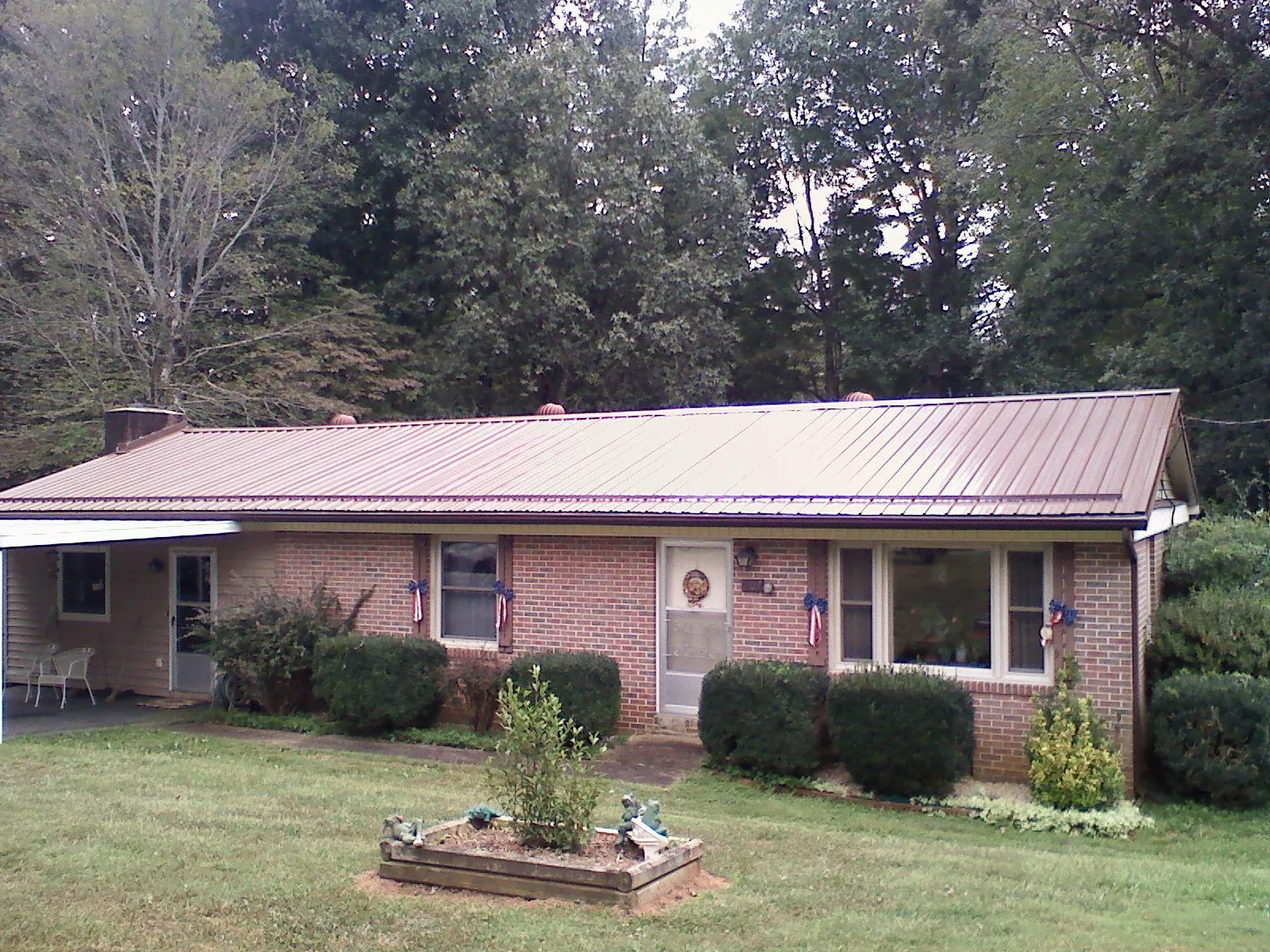 Bronze metal roof on a brick ranch home with a carport in Hammondsville