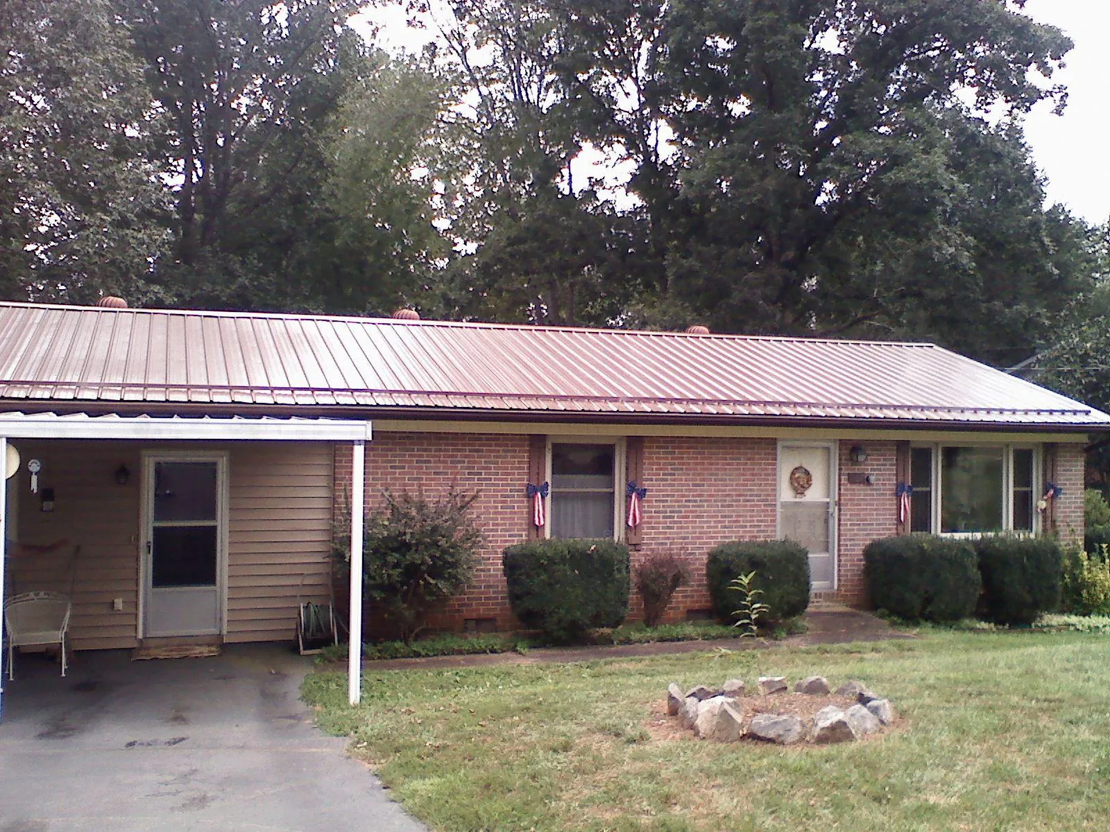 Bronze metal roof and carport on a brick ranch home — Roof Repair work by our crew in Hammondsville