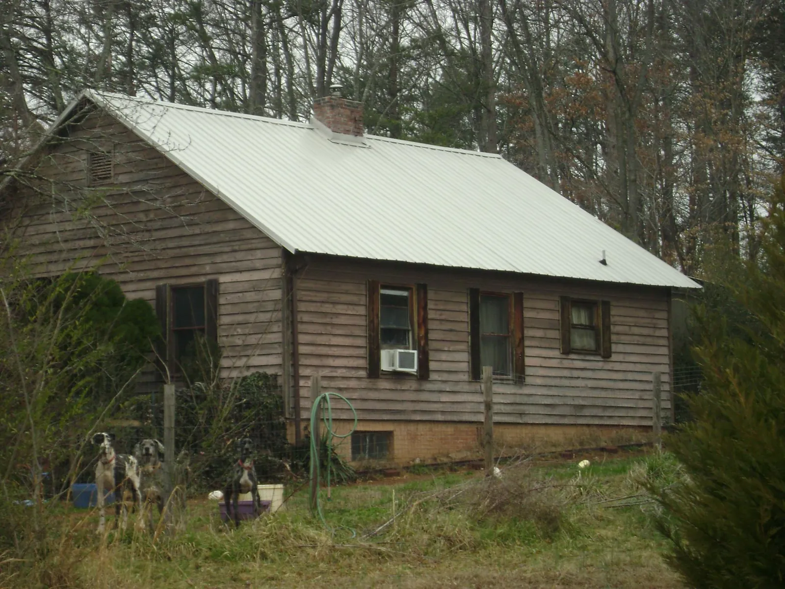 White metal roof on an old wood sided farmhouse, from a Metal Roof Installation job in Hammondsville